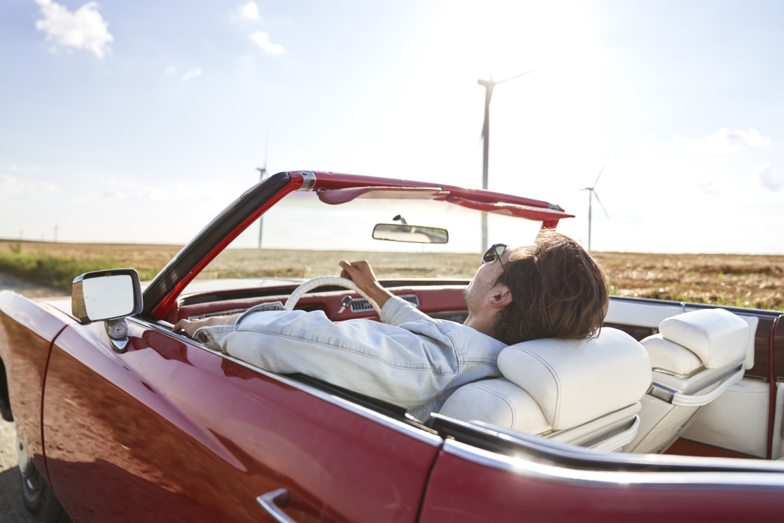 relaxed-man-driving-a-stylish-red-car